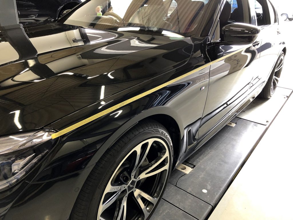 九州のBMW専門店スタディ福岡。BMW7シリーズにStudieAGロゴいりのボディストライプ貼り付けです!