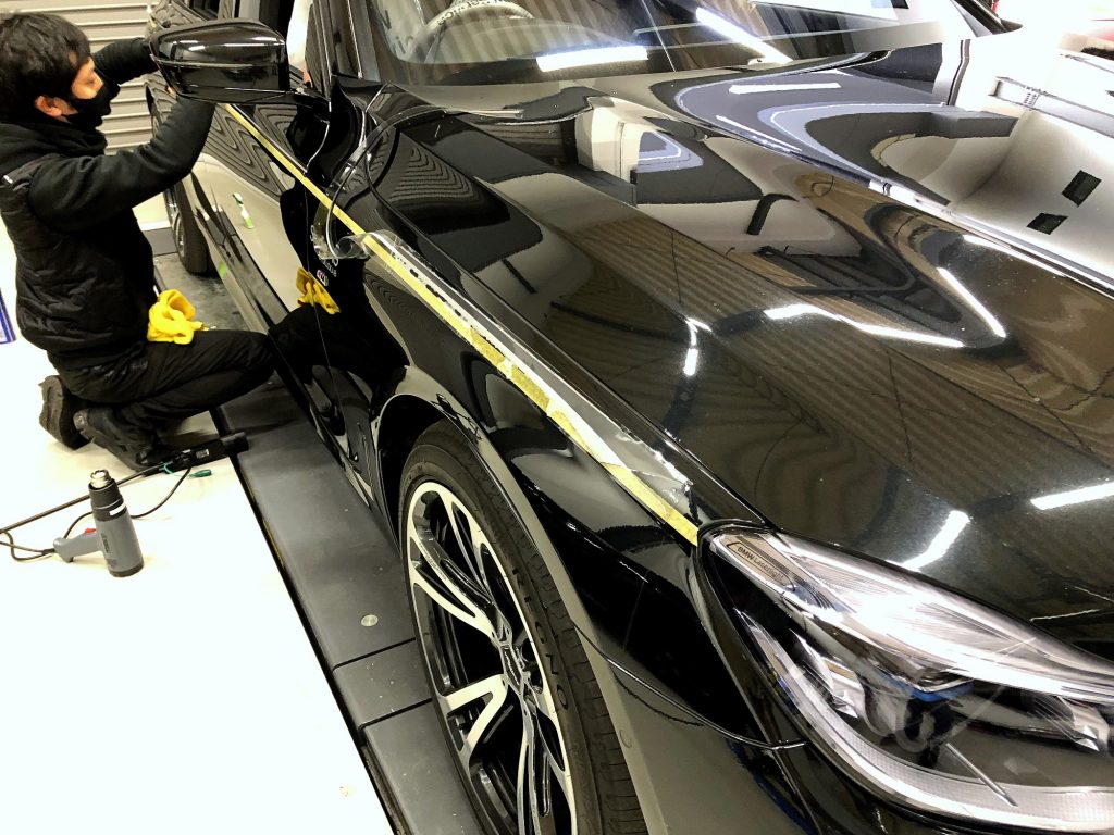 九州のBMW専門店スタディ福岡。BMW7シリーズにStudieAGロゴいりのボディストライプ貼り付けです!